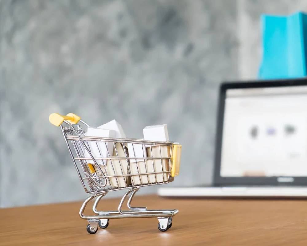 Shopping cart beside a laptop